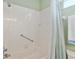 Bright bathroom featuring a shower with white tile and a grab bar for accessibility at 8904 Sw 84Th Cir, Ocala, FL 34481