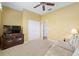 Bedroom featuring carpet, yellow walls, closet, and dresser with television at 8904 Sw 84Th Cir, Ocala, FL 34481