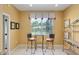 Bright breakfast nook with a glass-top table, two chairs, and natural light from a large window with decorative valance at 8904 Sw 84Th Cir, Ocala, FL 34481