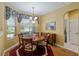 Cozy dining room with a round table, chandelier, and natural light from the windows at 8904 Sw 84Th Cir, Ocala, FL 34481