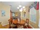 Inviting dining area with wood flooring, chandelier lighting, and elegant window treatments at 8904 Sw 84Th Cir, Ocala, FL 34481