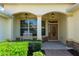 Close-up of charming home's front entrance with manicured shrubs and a brick walkway leading to the arched entryway at 8904 Sw 84Th Cir, Ocala, FL 34481