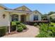 Close up of a charming single-story home entrance featuring manicured landscaping and a brick walkway at 8904 Sw 84Th Cir, Ocala, FL 34481