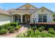 Close up of a charming single-story home entrance featuring lush landscaping and a brick walkway at 8904 Sw 84Th Cir, Ocala, FL 34481