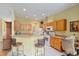 Open kitchen with breakfast bar, wooden cabinets, and tile flooring, perfect for casual dining at 8904 Sw 84Th Cir, Ocala, FL 34481