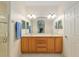 Bright bathroom featuring dual sinks, a large mirror, and a shower with a glass enclosure at 8904 Sw 84Th Cir, Ocala, FL 34481