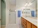 Comfortable bathroom featuring dual sinks, a shower with a glass enclosure and views of the exterior at 8904 Sw 84Th Cir, Ocala, FL 34481