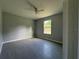 This bright bedroom features a ceiling fan, gray wood-look floors, and a window at 930 Nw 124Th Pl, Citra, FL 32113