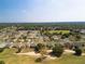 Aerial view showcases houses near a lush green golf course and tree-filled neighborhoods at 9347 Se 137Th Street Rd, Summerfield, FL 34491
