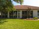 Backyard showcasing a well-maintained lawn, landscaped area, and covered porch at 9347 Se 137Th Street Rd, Summerfield, FL 34491