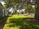 Lush backyard with mature trees, green grass and partial home view at 9347 Se 137Th Street Rd, Summerfield, FL 34491