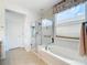 Bright bathroom featuring a glass-enclosed shower, soaking tub and plenty of natural light at 9347 Se 137Th Street Rd, Summerfield, FL 34491