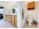 Bright bathroom featuring a double sink vanity and a separate toilet room at 9347 Se 137Th Street Rd, Summerfield, FL 34491