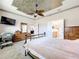 Spacious bedroom features a decorative ceiling, carpet and ensuite bathroom at 9347 Se 137Th Street Rd, Summerfield, FL 34491