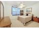 Cozy bedroom features neutral-colored carpet, ceiling fan, window, and furniture at 9347 Se 137Th Street Rd, Summerfield, FL 34491