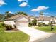 Well-maintained home featuring a pristine driveway, two-car garage, and manicured landscaping at 9347 Se 137Th Street Rd, Summerfield, FL 34491