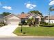 Charming home featuring a well-manicured lawn, beautiful landscaping, and an inviting front entrance at 9347 Se 137Th Street Rd, Summerfield, FL 34491