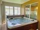 Relaxing hot tub in a sunroom with natural light and outside views at 9347 Se 137Th Street Rd, Summerfield, FL 34491