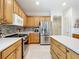 Kitchen featuring stainless steel appliances and wood cabinets with backsplash at 9347 Se 137Th Street Rd, Summerfield, FL 34491