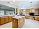 Open-concept kitchen featuring stainless steel appliances, custom island and oak cabinets at 9347 Se 137Th Street Rd, Summerfield, FL 34491