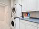Laundry room with stacked washer and dryer next to counter and cabinets at 9347 Se 137Th Street Rd, Summerfield, FL 34491