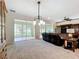 Bright living room with ceiling fan, carpet flooring, view of the sunroom, and entertainment center at 9347 Se 137Th Street Rd, Summerfield, FL 34491