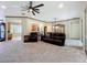 Open-concept living room featuring carpet flooring, and a view of the kitchen and dining areas at 9347 Se 137Th Street Rd, Summerfield, FL 34491