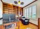 Home office with built-in bookshelves, hardwood floors, and natural light from the window at 9347 Se 137Th Street Rd, Summerfield, FL 34491