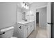 Bathroom featuring a white vanity with black hardware, a large mirror, and tile flooring at 9388 Sw 53Rd Pl, Ocala, FL 34481