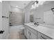 Well-lit bathroom featuring a bathtub, modern fixtures, and a vanity with white cabinets and black hardware at 9388 Sw 53Rd Pl, Ocala, FL 34481