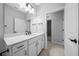Bright bathroom featuring a white vanity with black fixtures, a large mirror, and tiled flooring at 9388 Sw 53Rd Pl, Ocala, FL 34481