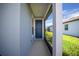 Inviting entryway showcasing a vibrant blue door with modern hardware and an attached screen room at 9388 Sw 53Rd Pl, Ocala, FL 34481