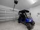 A well lit garage with an electric golf cart and a sectional garage door at 9388 Sw 53Rd Pl, Ocala, FL 34481