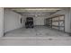 Spacious garage with an electric golf cart, epoxy flooring, storage, and access door at 9388 Sw 53Rd Pl, Ocala, FL 34481