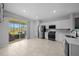 Modern kitchen features white cabinets, stainless steel appliances, tile flooring and sliding door access to screened patio at 9388 Sw 53Rd Pl, Ocala, FL 34481