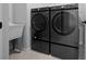 Convenient laundry room equipped with modern washer and dryer units, complemented by a utility sink at 9388 Sw 53Rd Pl, Ocala, FL 34481
