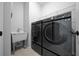 Modern laundry room featuring new side-by-side machines, a utility sink, and ample space at 9388 Sw 53Rd Pl, Ocala, FL 34481