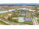 Aerial view showcasing the tennis and pickleball courts, baseball field, and lake at 9740 Sw 68Th Ln, Ocala, FL 34481