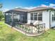 Charming back porch with seating area and railing overlooking the well-manicured backyard at 9740 Sw 68Th Ln, Ocala, FL 34481