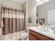 Cozy bathroom featuring a shower with curtain, vanity, and well-lit mirror at 9740 Sw 68Th Ln, Ocala, FL 34481