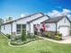 Inviting home with stone accents, flags, manicured landscaping, and a brick paver driveway at 9740 Sw 68Th Ln, Ocala, FL 34481