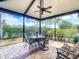 Relaxing screened patio with ceiling fan, brick floor and comfortable seating and manicured landscaping at 9740 Sw 68Th Ln, Ocala, FL 34481
