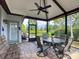 Inviting screened patio with brick flooring, comfortable seating, and view of the lush green yard at 9740 Sw 68Th Ln, Ocala, FL 34481