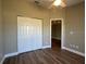 Bedroom featuring hardwood floors, a ceiling fan, and a closet with sliding doors at 9934 Se 64Th Ave, Belleview, FL 34420