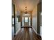 Bright foyer featuring wood-look floors, neutral walls, and a decorative chandelier, creating an inviting entrance at 9934 Se 64Th Ave, Belleview, FL 34420