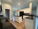 An open kitchen featuring granite countertops, black appliances, a center island, and light wood-look flooring at 9934 Se 64Th Ave, Belleview, FL 34420