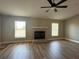 Spacious living room with a fireplace, ceiling fan, and hardwood floors at 9934 Se 64Th Ave, Belleview, FL 34420