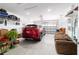 Spacious garage featuring a parked red SUV, overhead storage, and ample space for parking and storage at 10033 Sw 96Th St, Ocala, FL 34481