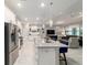 Open kitchen featuring a large island with bar seating, stainless steel appliances, and elegant pendant lighting at 10033 Sw 96Th St, Ocala, FL 34481