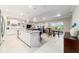 Open-concept kitchen, dining, and living space with marble floors and bright, natural light at 10033 Sw 96Th St, Ocala, FL 34481